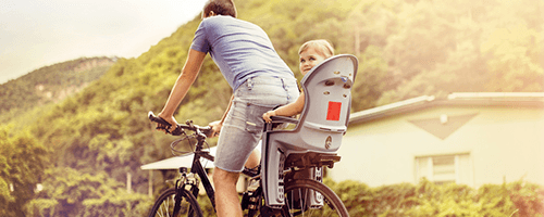 Radfahrender Varter mit Kind in Kinderfahrradsitz