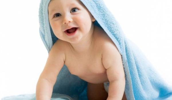 Baby lächelt unter einem Handtuch